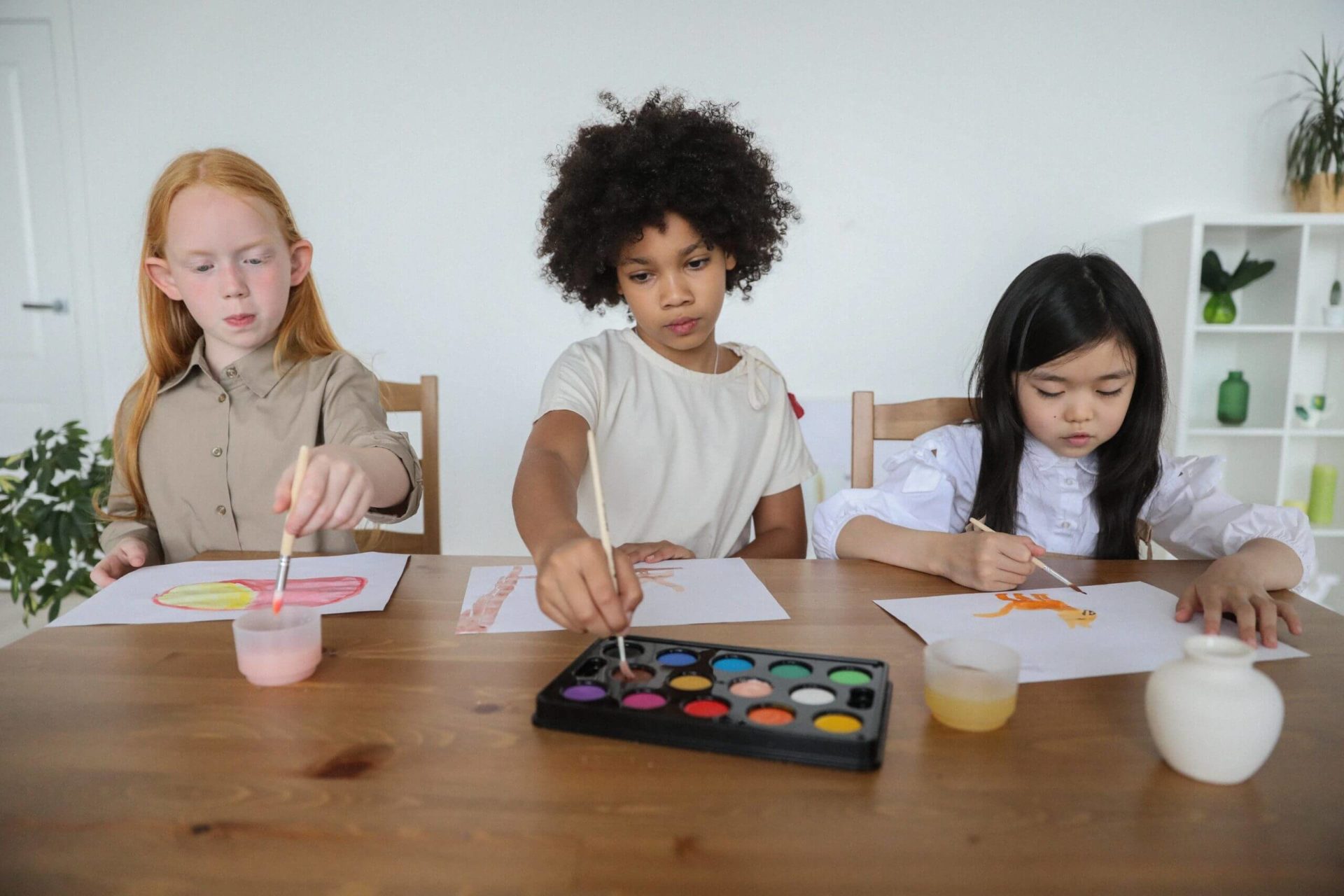 3 girls painting at table